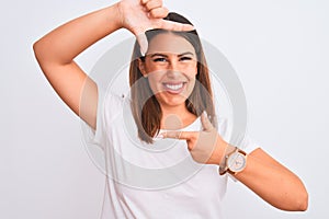 Portrait of beautiful and young brunette woman standing over isolated white background smiling making frame with hands and fingers