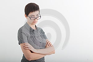 Portrait of beautiful young business woman or angry female teacher accusingly frowning over her glasses