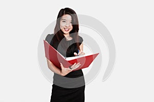 Portrait of beautiful young businesswoman writing notes in folder over white background