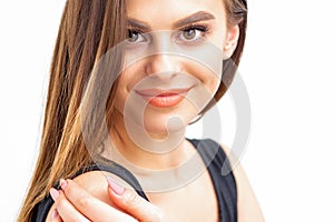 Portrait of a beautiful young caucasian smiling brunette woman with long straight hair standing and looking at the