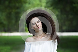 Portrait of a beautiful young caucasian woman with flying long hair, clean skin and casual makeup