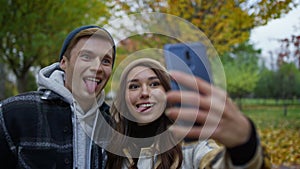 Portrait of beautiful young couple in love taking selfie with tongues.