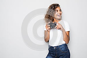 Portrait of beautiful young curly mixed race woman photographer isolated over white background holding camera.