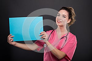 Portrait of beautiful young doctor holding blue cardboard photo