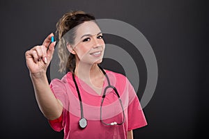 Portrait of beautiful young doctor holding blue pill photo