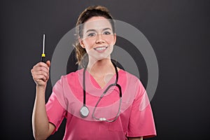 Portrait of beautiful young doctor holding screwdriver photo