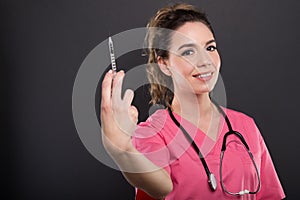 Portrait of beautiful young doctor holding syringe photo
