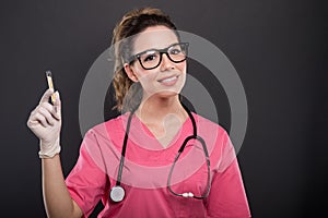 Portrait of beautiful young doctor holding thermometer photo