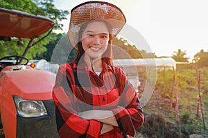 Portrait of a beautiful young farmer working in the field with a tractor