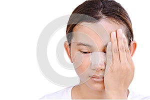 Portrait of beautiful young female face with bandage on her nose - beauty treatment plastic surgery isolated on gray background