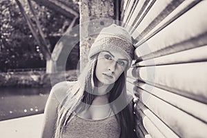 Portrait of beautiful young female model, leaning against a garage door.