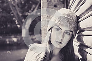 Portrait of beautiful young female model, leaning against a garage door.