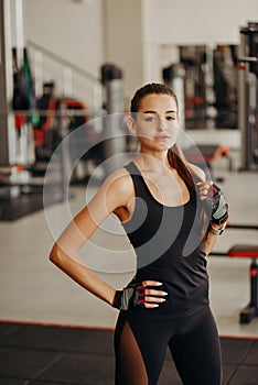 Portrait of beautiful young fit woman during training in the gym at the fitness center