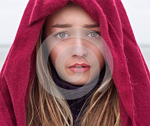 Portrait of a beautiful young girl with big eyes with a sad mood, sadness on her face with krestnym handkerchief on head