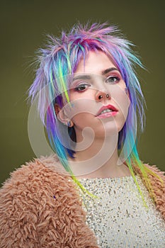 Portrait of a beautiful young girl with dyed colored hair. Hairstyle and makeup. Fashion shooting for the hairdresser