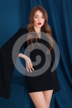 Portrait of beautiful young girl in a fashionable black dress