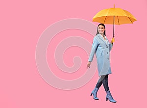 Portrait of beautiful young girl holding yellow umbrella