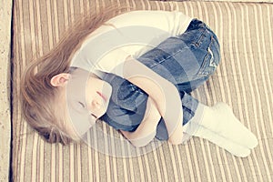 Portrait of beautiful young girl laying on bed hugging herself smiling eyes closed & dreaming