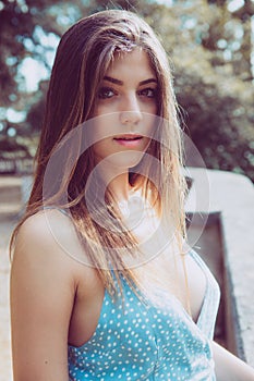 Portrait of a beautiful young girl. Long brown hair. Big eyes and intense gaze. Outdoors, daylight