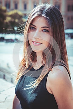 Portrait of a beautiful young girl. Long brown hair. Big eyes and intense gaze. Outdoors, daylight