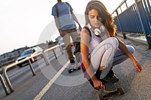 Portrait of beautiful young girl with skateboard in the city outdoors. People hobby sport concept