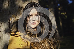 Portrait beautiful young girl smiling lean against tree in the park