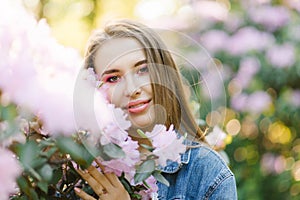 Portrait of a beautiful young girl with straight hair in rhododendron colors