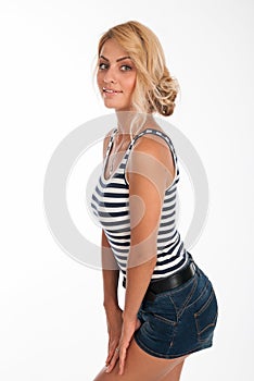 Portrait of a beautiful young girl in a striped T-shirt and jeans shorts isolated over white