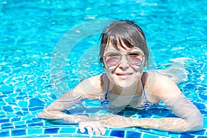 Portrait of a beautiful young girl in sunglasses floating in the