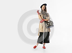 Portrait of beautiful young girl, teen in retro style clothes posing at white studio background. Concept of emotions