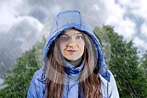 Portrait of beautiful young girl wearing aincoat with hood in a
