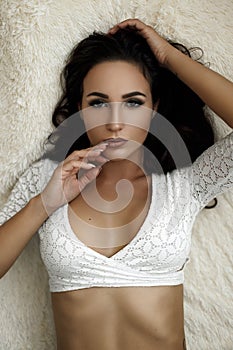 Portrait of a beautiful young girl in white lingerie lies