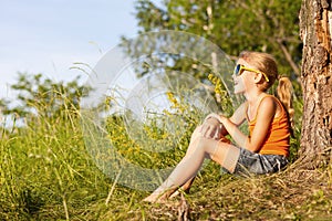 Portrait of a beautiful young girl with wildflowers in park