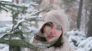 Portrait of a beautiful young girl in a winter park near the Christmas tree. slow motion