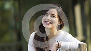 Portrait of a beautiful young Hispanic woman in the middle of a park with a very cheerful attitude against a background of