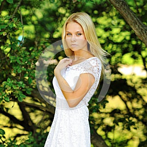 Portrait of a beautiful young lady in summer green park