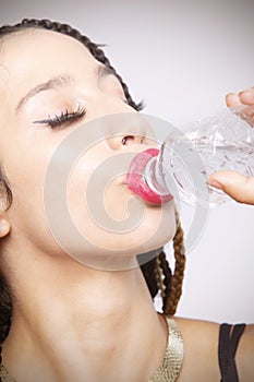 Portrait of beautiful young Latina woman taking a swig