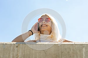 Portrait of a beautiful young latina woman in a white t-shirt talking smiling on a cell phone. Copyspace