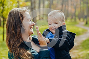 Portrait of a beautiful young mother with her son walks in the autumn park