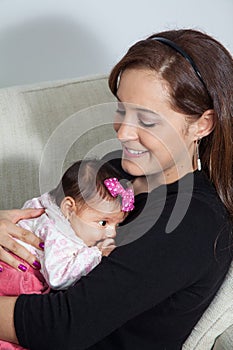 Portrait of beautiful young mother at home with her one month baby girl. Motherhood concept. Family love concept