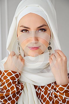 Portrait of beautiful young muslim arabian woman wearing white hijab looking at camera photo