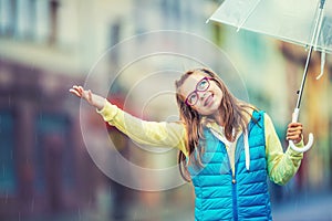 Portrait of beautiful young pre-teen girl with umbrella under rain