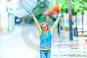 Portrait of beautiful young pre-teen girl with umbrella under rain