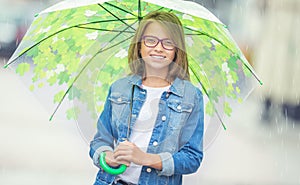 Portrait of beautiful young pre-teen girl with umbrella under spring or summer rain