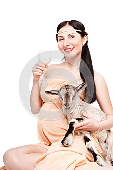 Portrait of a beautiful young pregnant woman with a goat