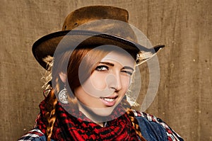 Portrait of a beautiful young red-haired girl in a cowboy hat