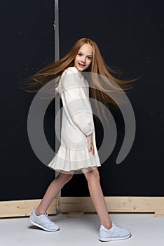 Portrait of beautiful young redhead girl posing in studio.