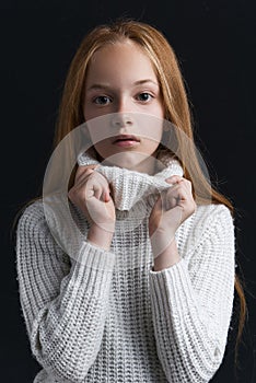 Portrait of beautiful young redhead girl posing in studio.