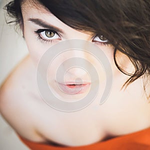 Portrait of a beautiful young brunette girl with expressive eyes and full lips
