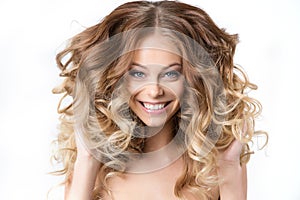 Portrait of beautiful young smiling girl with luxuriant hair curling. photo